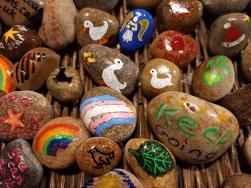 a photograph of some pebbles painted with affirming images and words