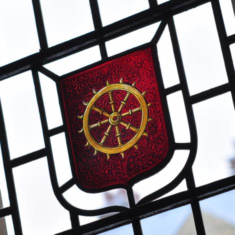Detail from a stained glass window featuring a wheel