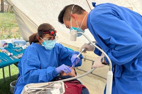 Dentist and assistant treat a patient in a mobile clinic in the Himalayas