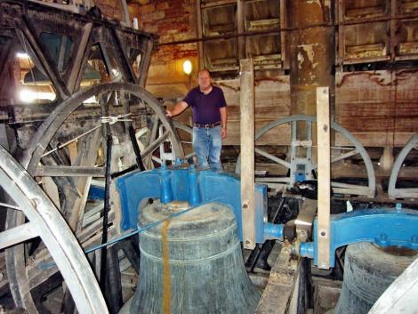Graham Darke standing by the Tenor bell at Wells Cathedral