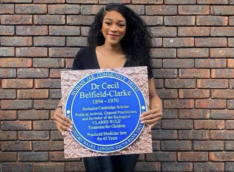 L'myah Sherae holding a blue plaque for Dr Cecil Belfield Clarke