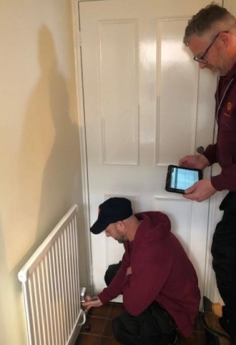 The maintenance team installing EcoSync system to a radiator