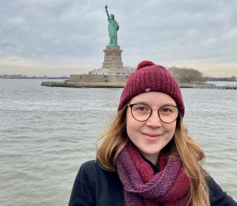 Dr Sophie Koudmani in New York City in front of the Statue of Liberty