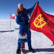 Garrett Curran flies the St Catharine's College flag at the South Pole